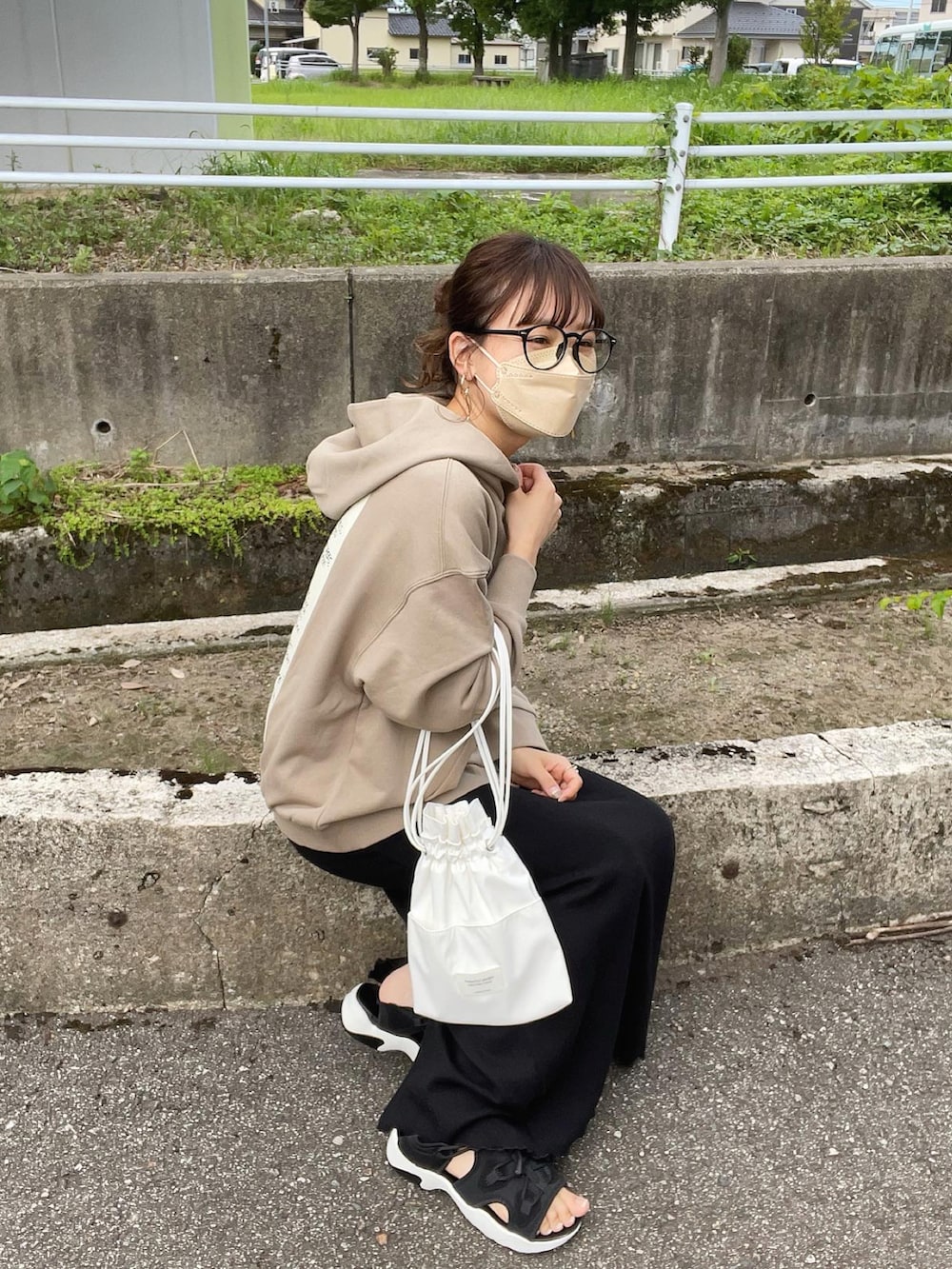 ベージュ系のパーカー、ブラック系のワンピース、ホワイト系のショルダーバッグを着用したレディースの夏コーディネートの4枚目の写真