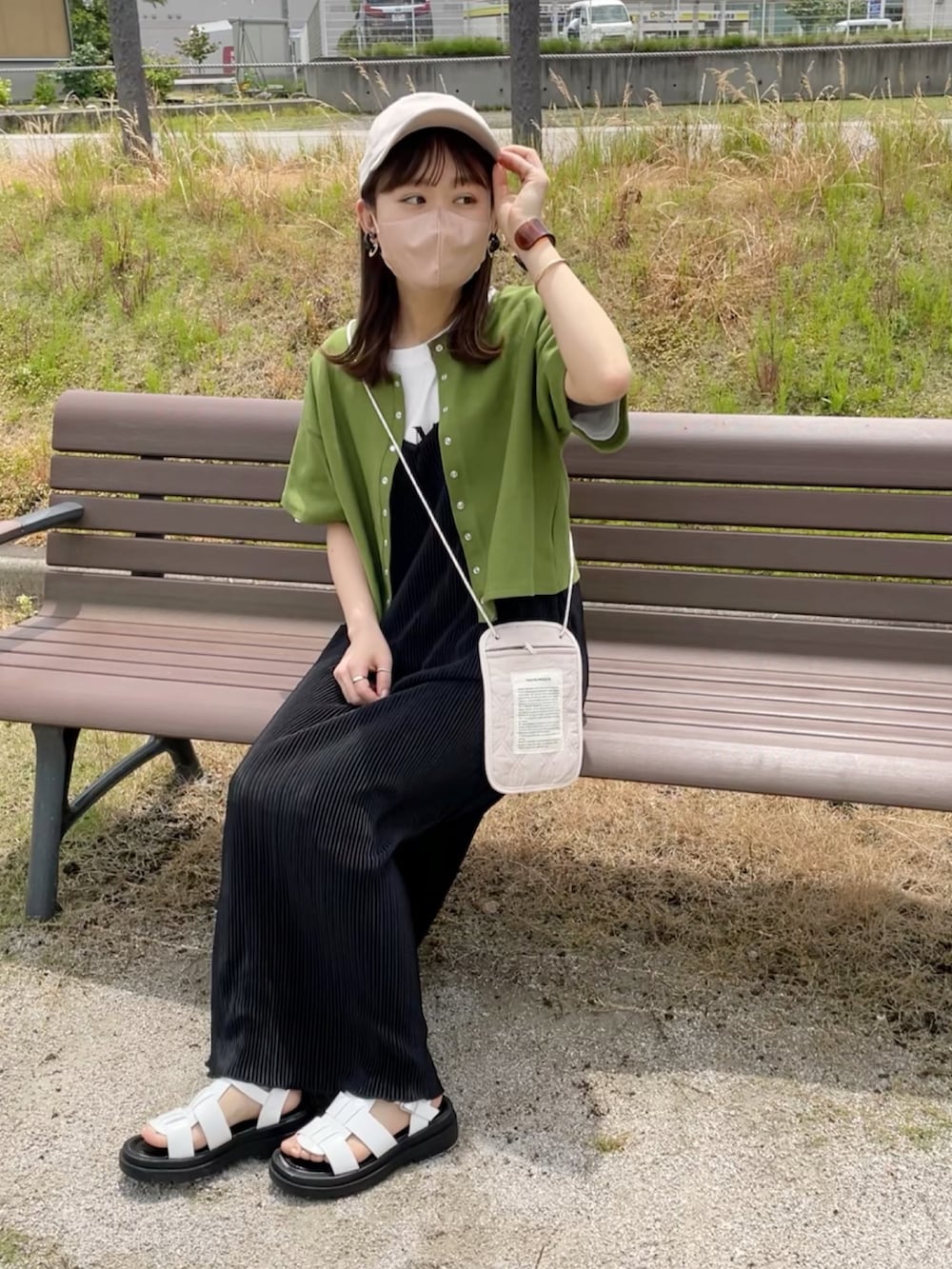 グリーン系のカーディガン/ボレロ、ホワイト系のTシャツ/カットソー、ブラック系のワンピース/ドレスを着用したレディースの春コーディネートの2枚目の写真