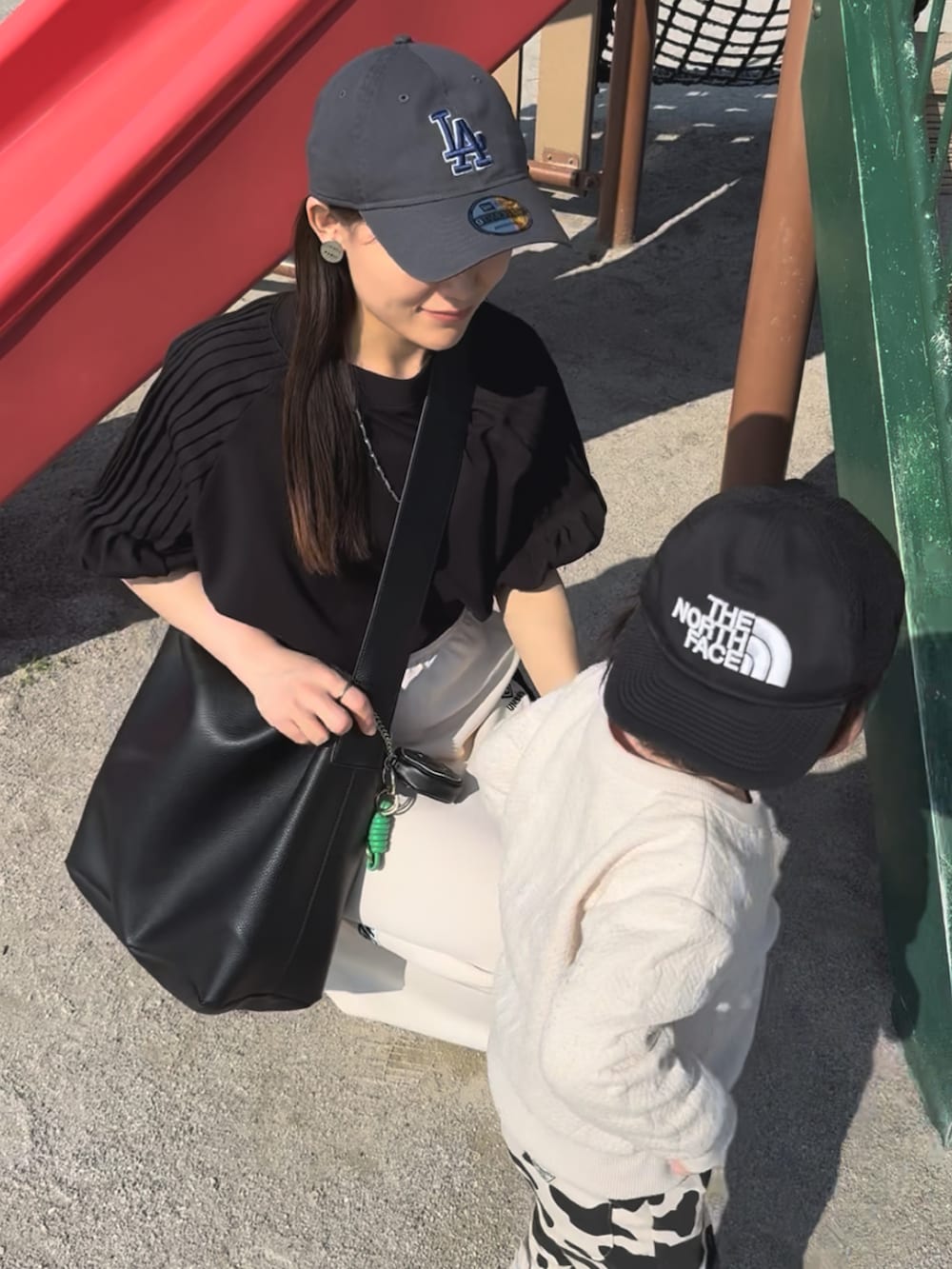 ブラック系のシャツ/ブラウス、ホワイト系のスカート、ベージュ系のスニーカーを着用したレディースの夏コーディネートの3枚目の写真