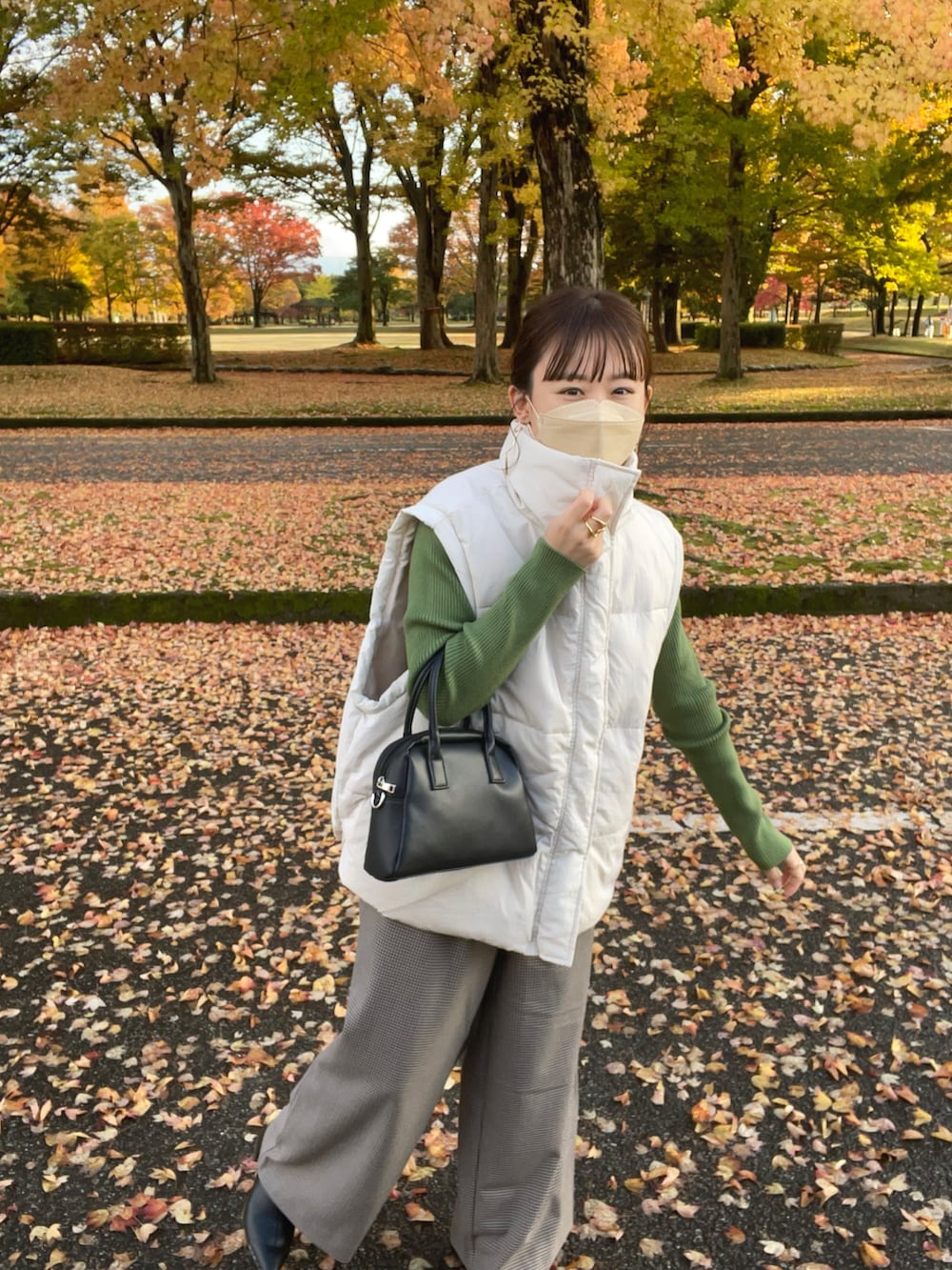 ベージュ系のその他パンツ、ホワイト系のダウンベスト、グリーン系のニット/セーターを着用したレディースの秋コーディネートの3枚目の写真