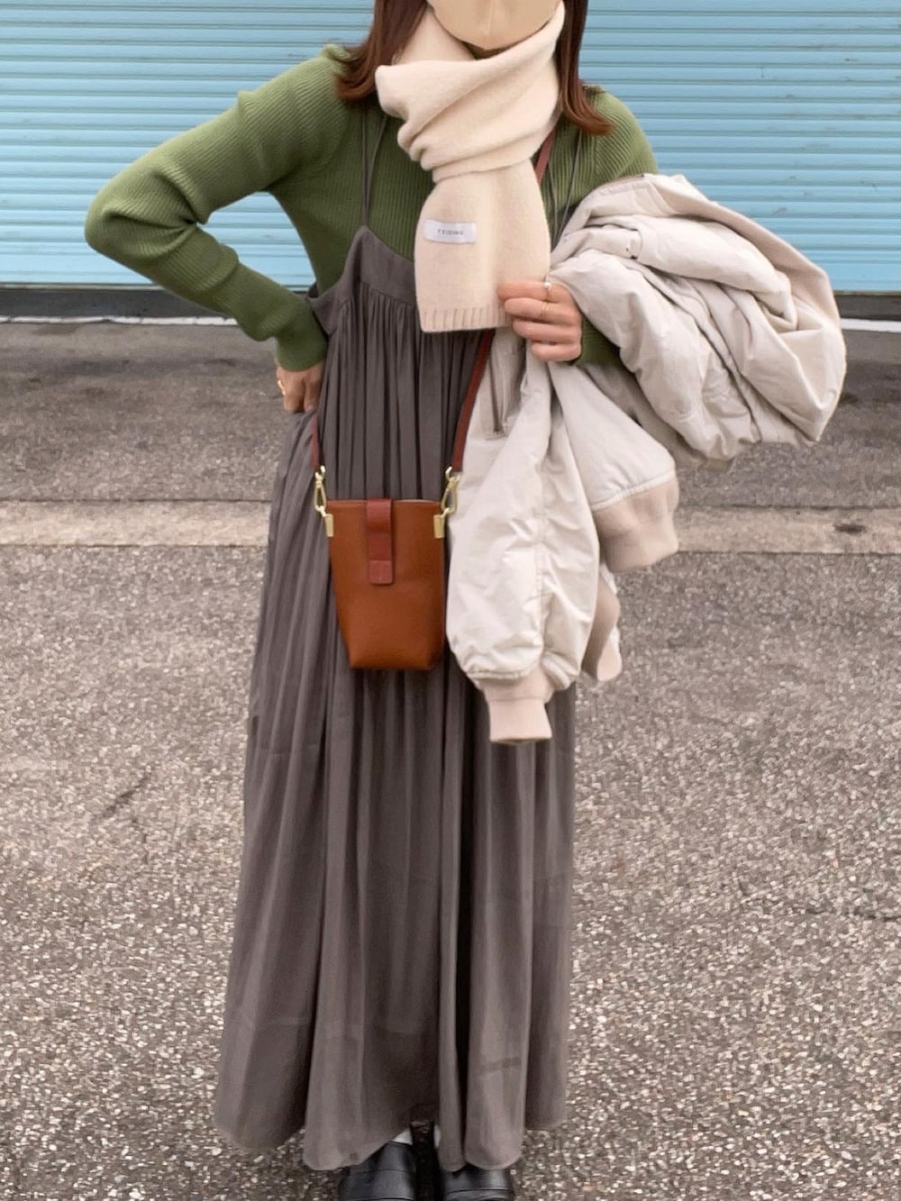 グリーン系のスカート、グリーン系のニット/セーター、グレー系のMA-1を着用したレディースの秋コーディネートの4枚目の写真