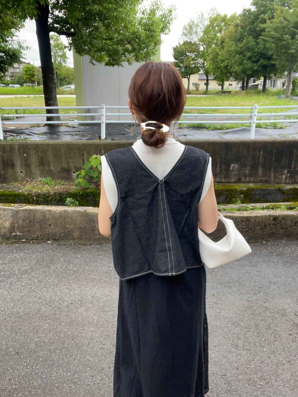 ブラック系のベスト、ホワイト系のニット/セーター、ブラック系のワンピースを着用したレディースの夏コーディネートの5枚目の写真
