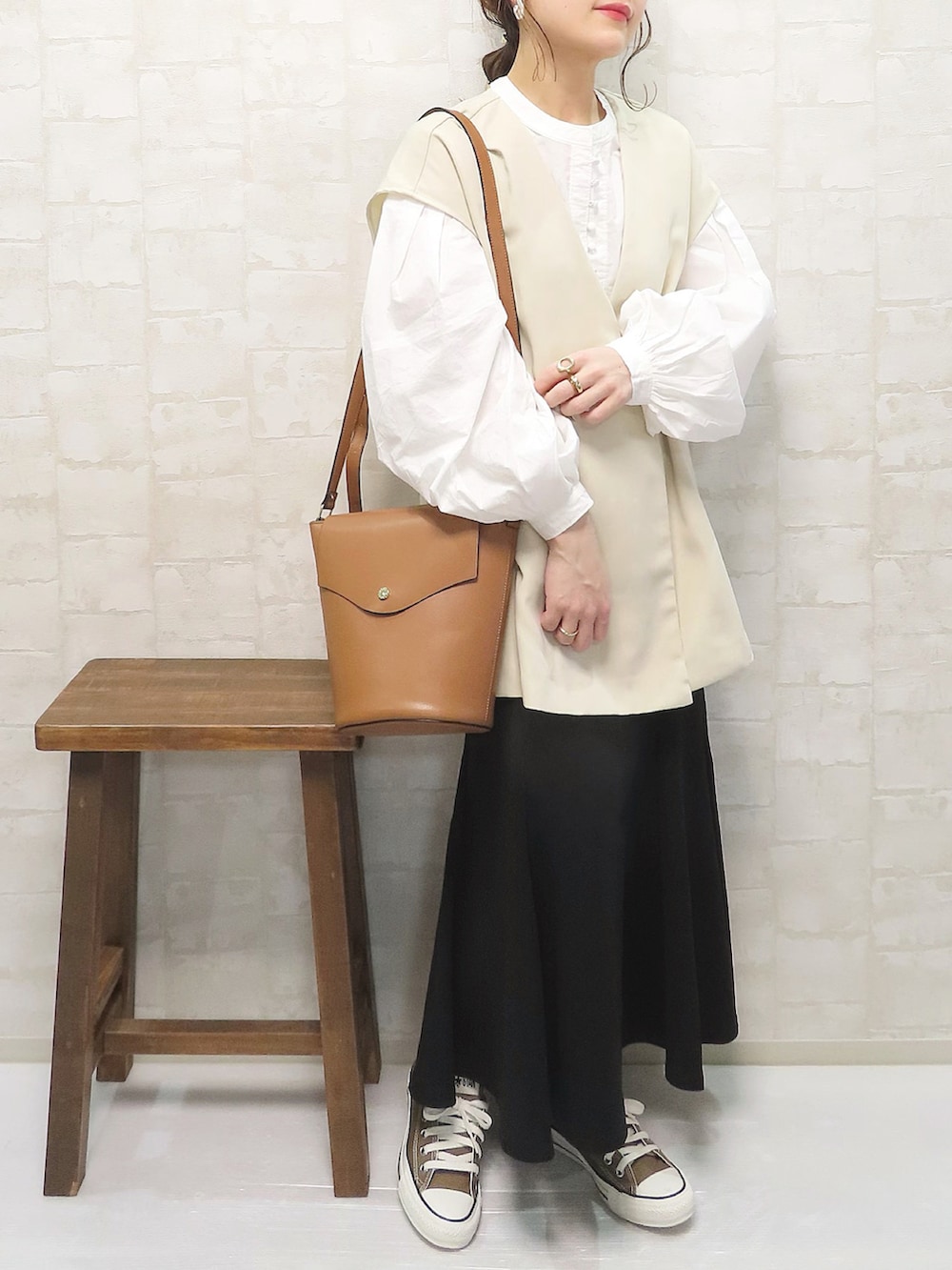 ホワイト系のシャツ/ブラウス、ホワイト系のベスト、ブラック系のスカートを着用したレディースの春コーディネートの3枚目の写真