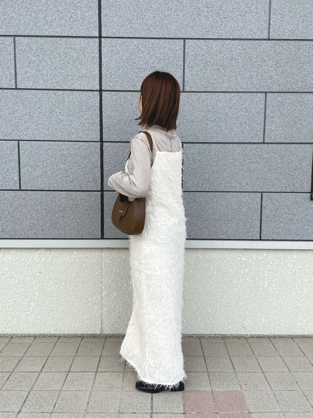 ホワイト系のワンピース、ベージュ系のTシャツ/カットソー、ブラウン系のバッグを着用したレディースの秋コーディネートの2枚目の写真