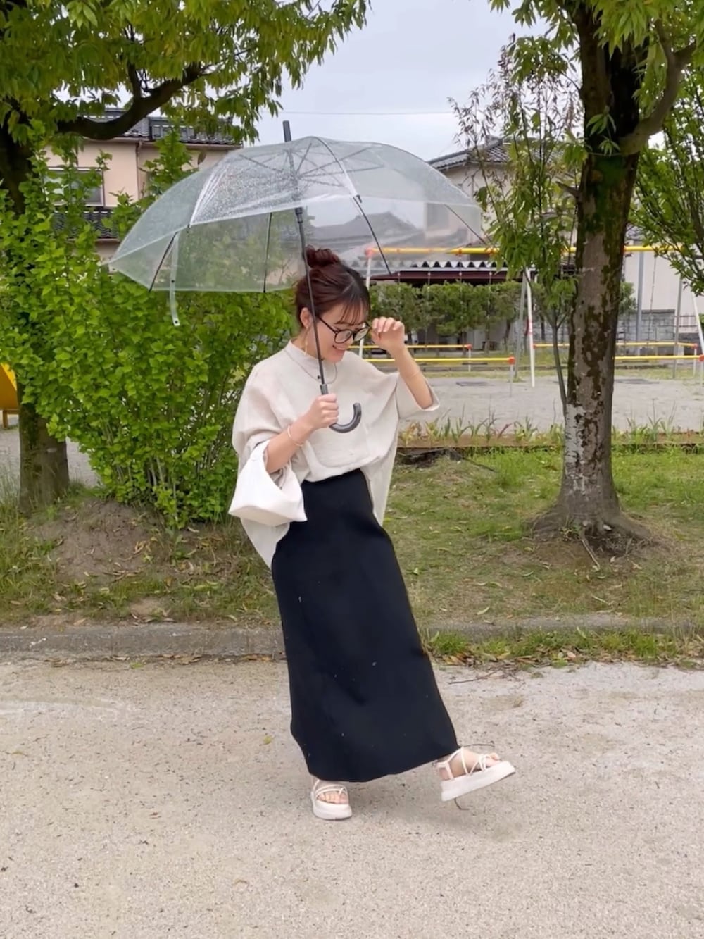 グレー系のシャツ/ブラウス、ブラック系のスカート、ホワイト系のハンドバッグを着用したレディースの春コーディネートの2枚目の写真