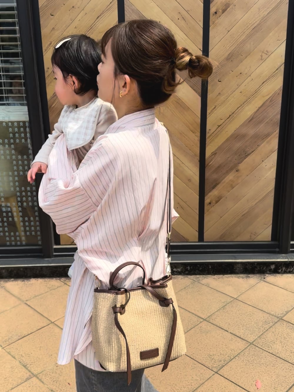 ピンク系のシャツ/ブラウス、ブラック系のデニムスカート、ブラウン系のトートバッグを着用したレディースの春コーディネートの3枚目の写真