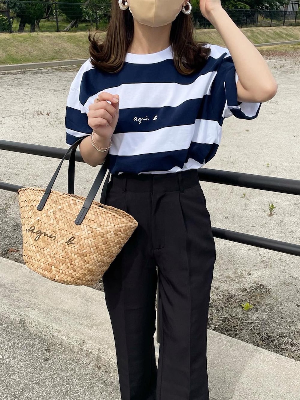 ブルー系のTシャツ/カットソー、ブラック系のスラックス、ブラック系のかごバッグを着用したレディースの夏コーディネートの3枚目の写真