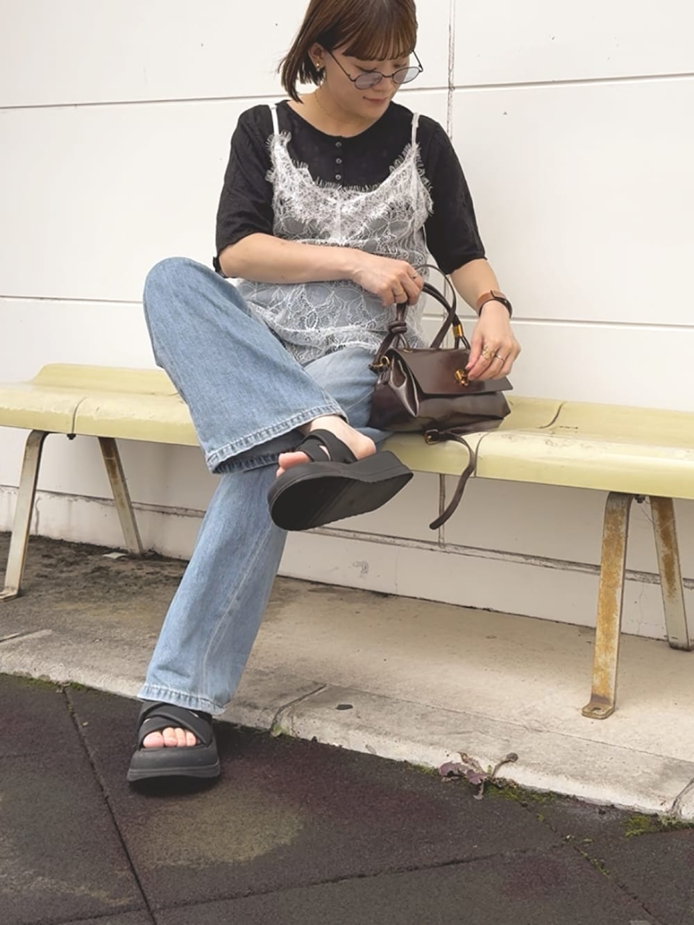 ホワイト系のキャミソール、ブラック系のTシャツ/カットソー、ブルー系のデニムパンツを着用したレディースの夏コーディネートの3枚目の写真