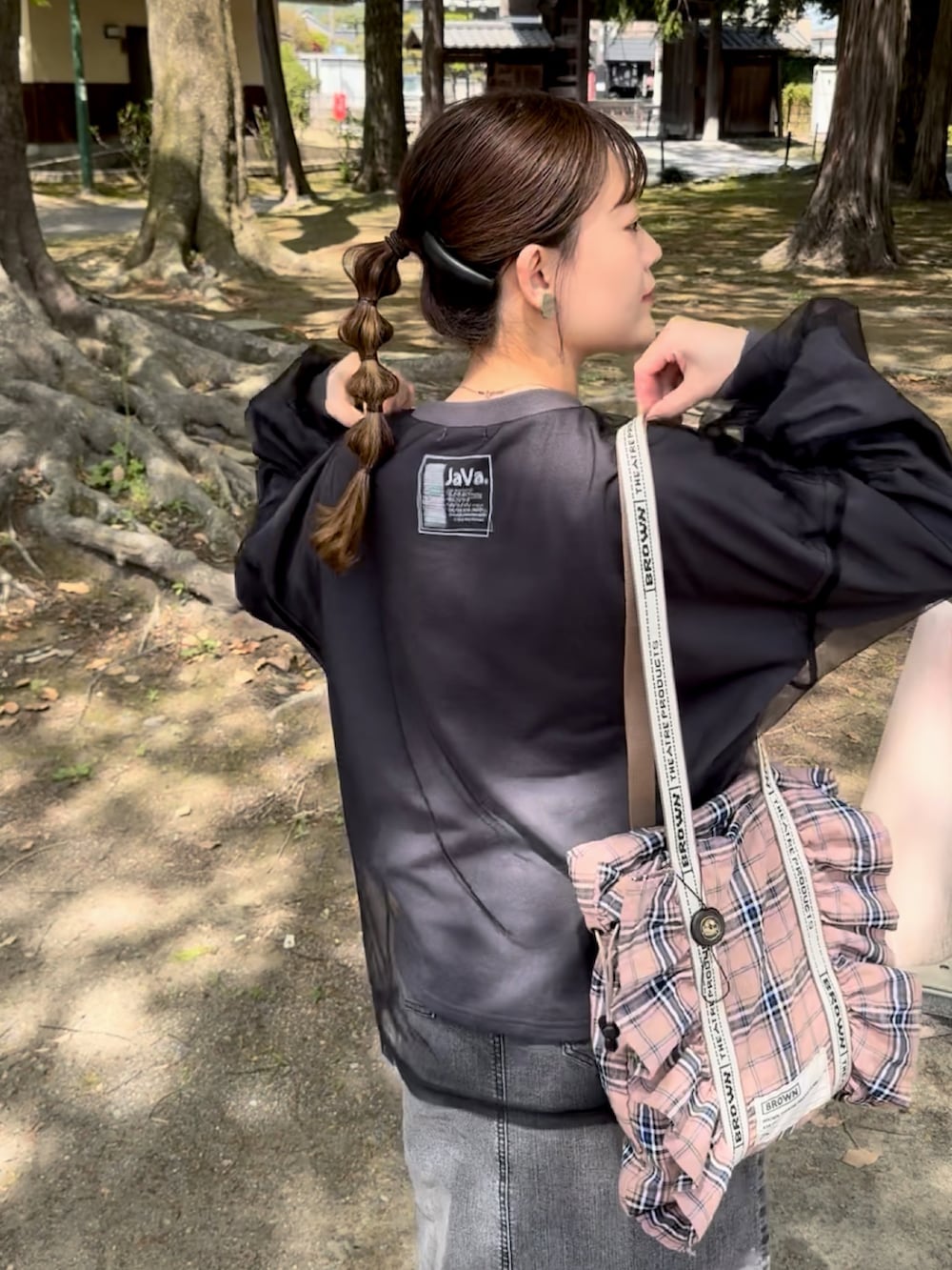 グレー系のTシャツ/カットソー、ピンク系のトートバッグ、ブラック系のデニムスカートを着用したレディースの春コーディネートの2枚目の写真