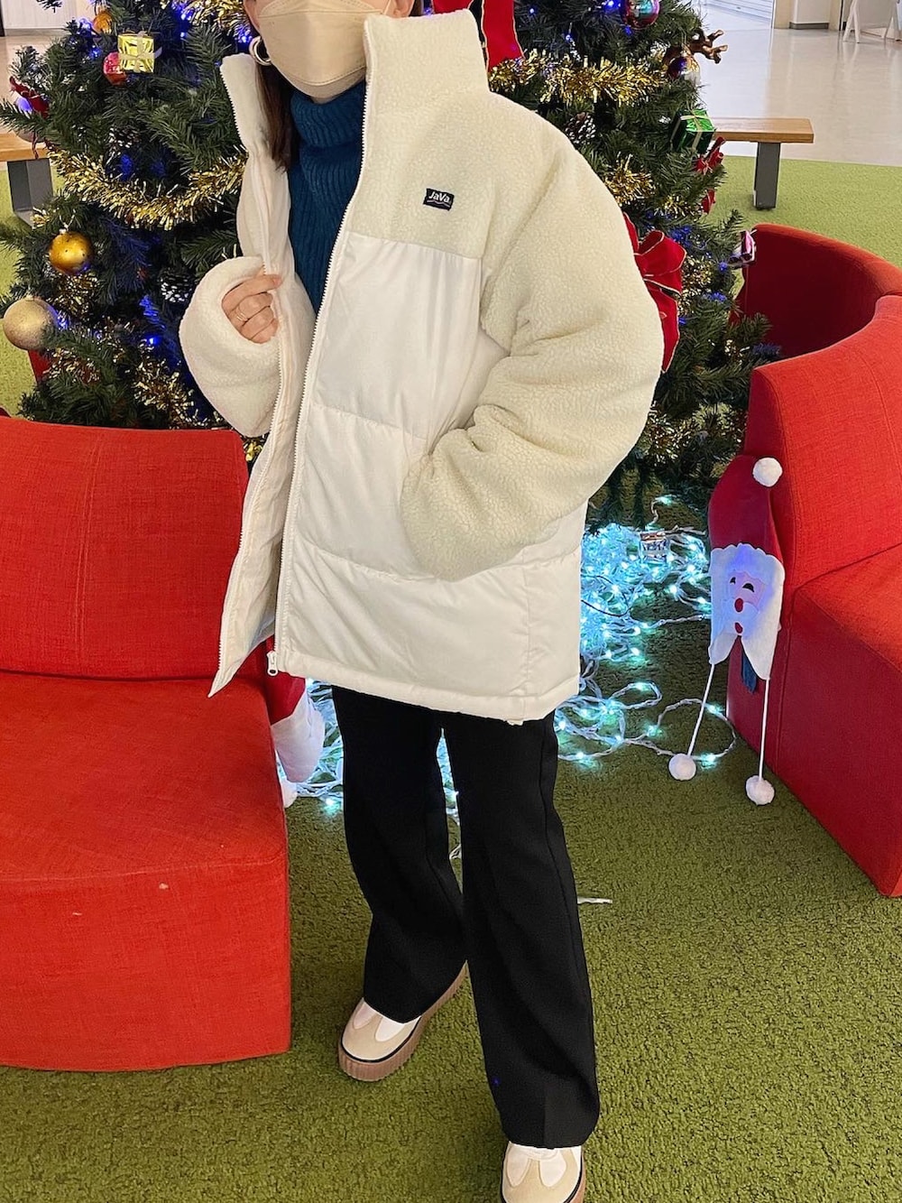 ホワイト系のダウンジャケット/コート、ブルー系のニット/セーター、ブラック系のスラックスを着用したレディースの冬コーディネートの3枚目の写真