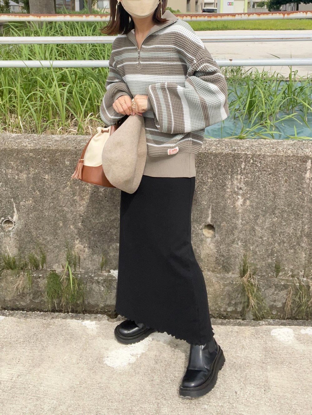 ブルー系のニット/セーター、ブラック系のワンピース、ブラウン系のショルダーバッグを着用したレディースの秋コーディネートの4枚目の写真