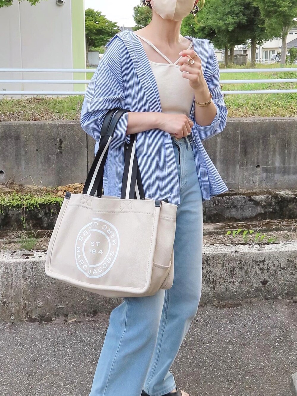 ブルー系のデニムパンツ、ホワイト系のキャミソール、ブルー系のシャツ/ブラウスを着用したレディースの夏コーディネートの4枚目の写真