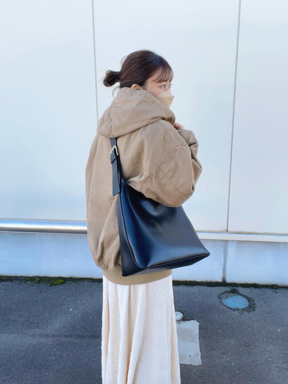 ベージュ系のブルゾン、ホワイト系のTシャツ/カットソー、ベージュ系のスカートを着用したレディースの春コーディネートの5枚目の写真