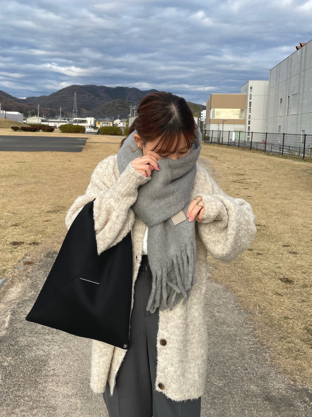 ベージュ系のカーディガン/ボレロ、グレー系のその他パンツ、ブラック系のトートバッグを着用したレディースの冬コーディネートの2枚目の写真