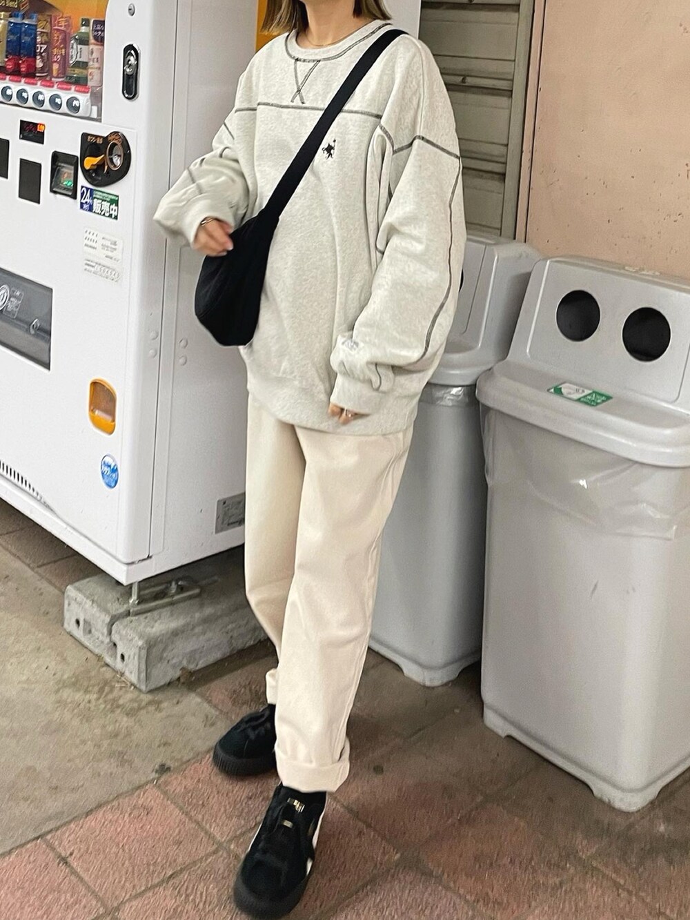 ベージュ系のスウェット、ベージュ系のデニムパンツ、ブラック系のショルダーバッグを着用したレディースの秋コーディネートの3枚目の写真