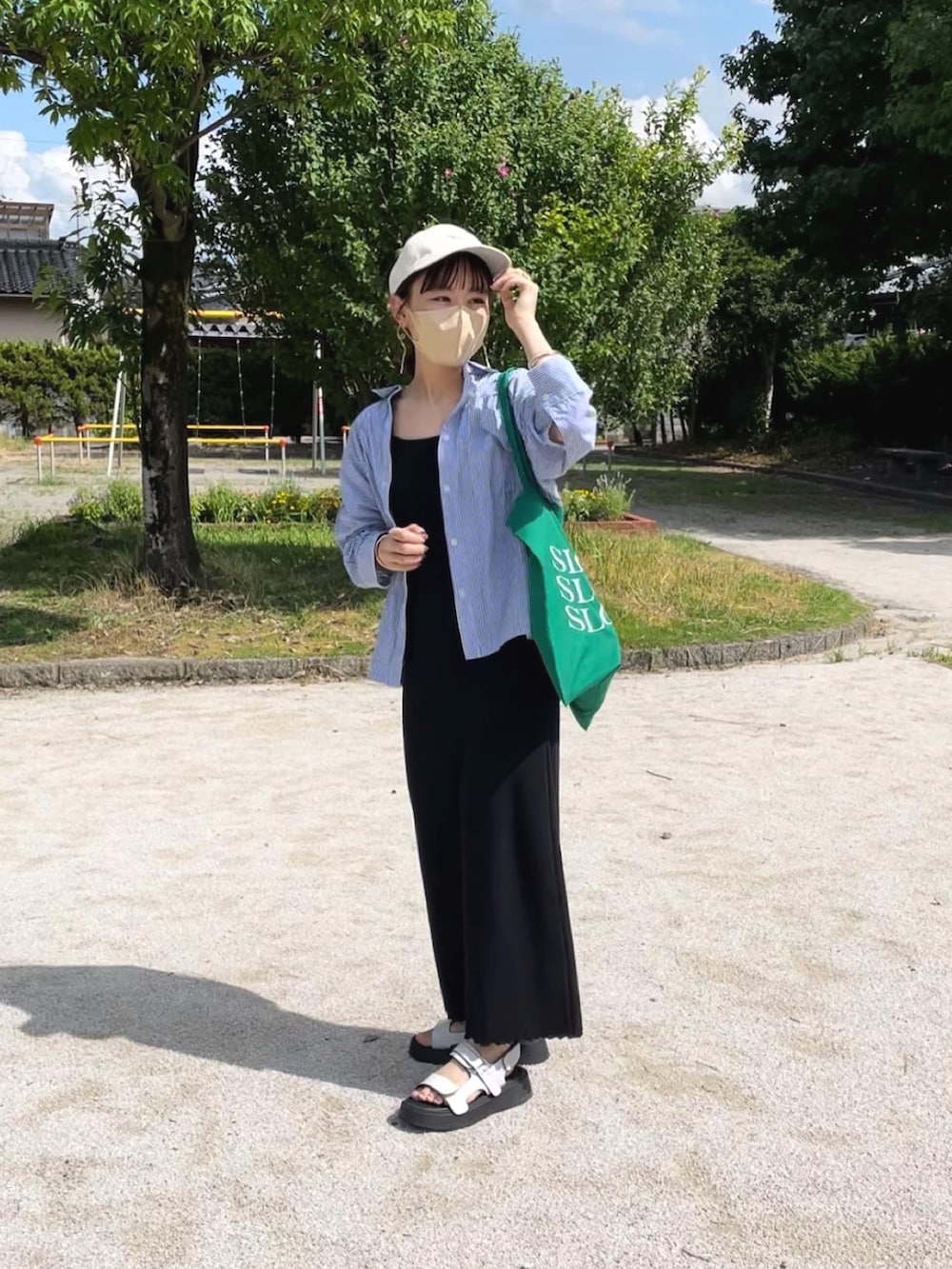 ブラック系のワンピース、ブルー系のシャツ/ブラウス、グリーン系のトートバッグを着用したレディースの夏コーディネートの4枚目の写真