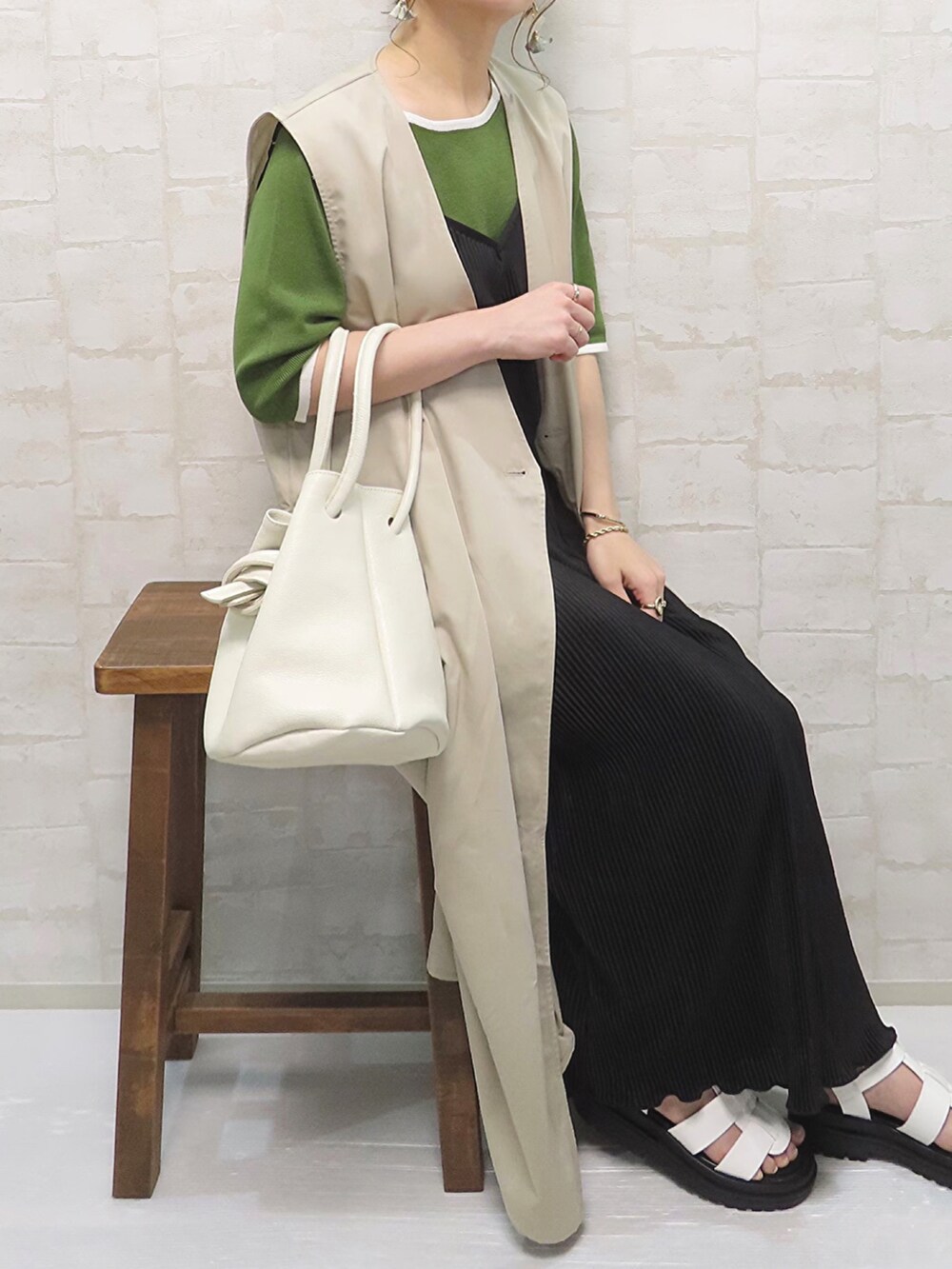 グリーン系のトップス、ブラック系のワンピース/ドレス、ベージュ系のベストを着用したレディースの夏コーディネートの5枚目の写真