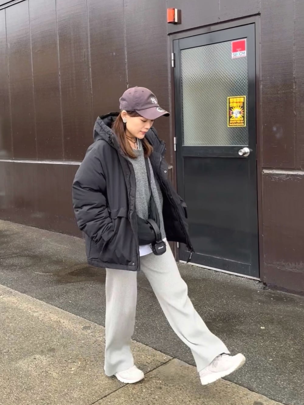 ブラック系のダウンジャケット/コート、グレー系のニット/セーター、グレー系のパンツを着用したレディースの冬コーディネートの5枚目の写真