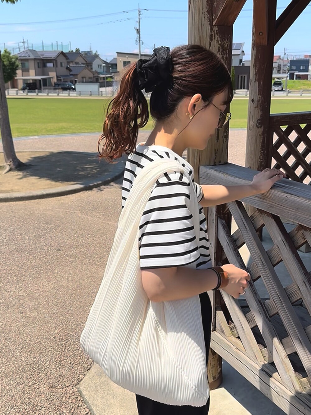 ホワイト系のTシャツ/カットソー、ブラック系のスウェットパンツ、ホワイト系のバッグを着用したレディースの夏コーディネートの5枚目の写真