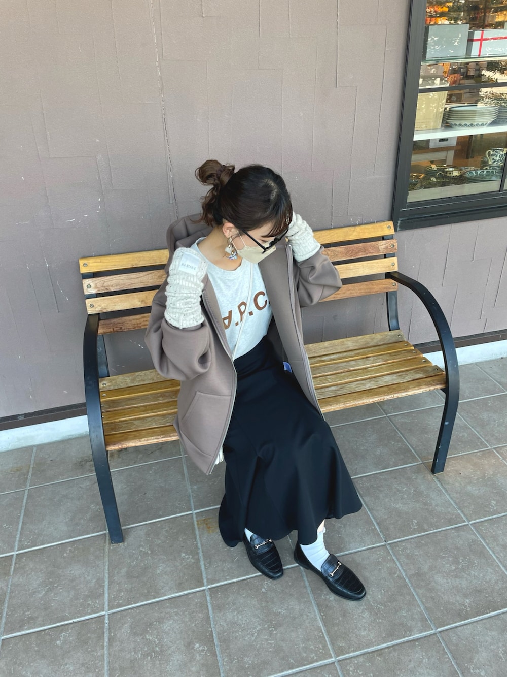 ブラウン系のパーカー、ブラック系のスカート、ホワイト系のTシャツ/カットソーを着用したレディースの秋コーディネートの3枚目の写真