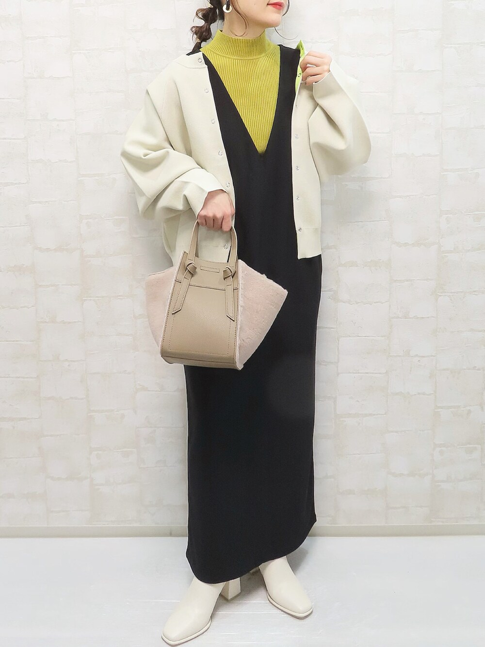 ベージュ系のニット/セーター、グリーン系のニット/セーター、ブラック系のデニムパンツを着用したレディースの冬コーディネートの5枚目の写真