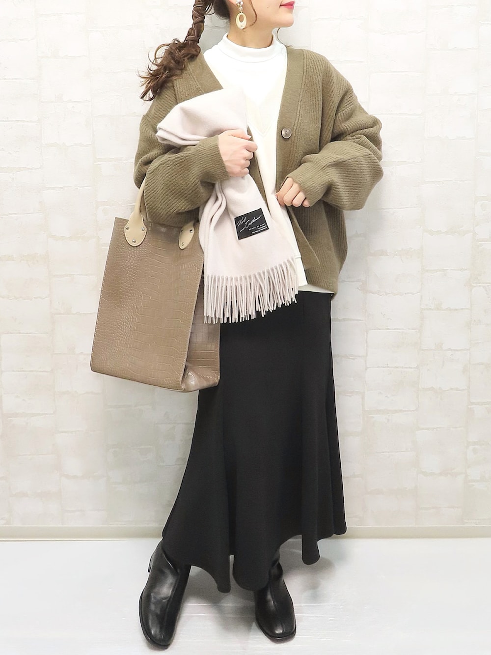 ブラウン系のトートバッグ、ブラウン系のカーディガン/ボレロ、ホワイト系のスウェットを着用したレディースの冬コーディネートの3枚目の写真