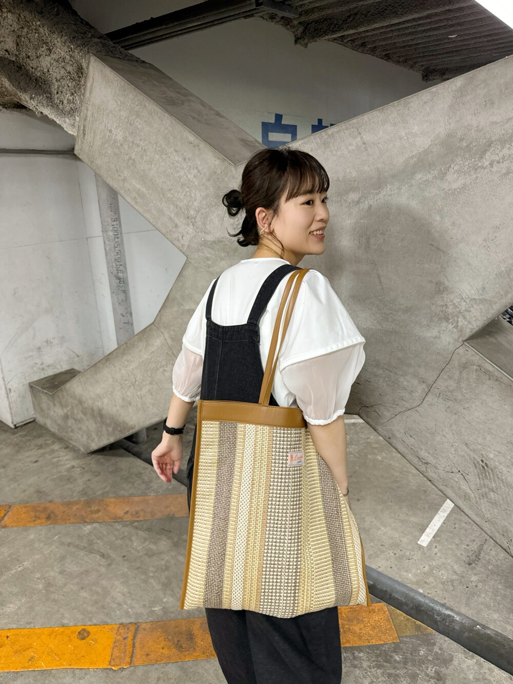 ホワイト系のシャツ/ブラウス、ブラック系のオールインワン・サロペット、ベージュ系のトートバッグを着用したレディースの夏コーディネートの4枚目の写真