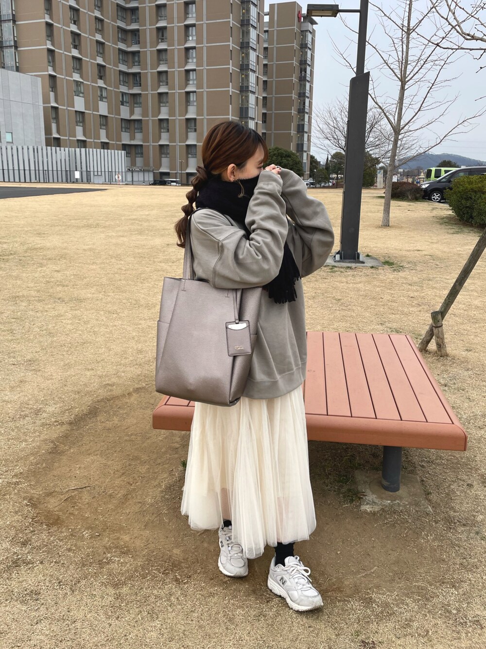 ベージュ系のスウェット、ホワイト系のスカート、ホワイト系のスニーカーを着用したレディースの冬コーディネートの4枚目の写真
