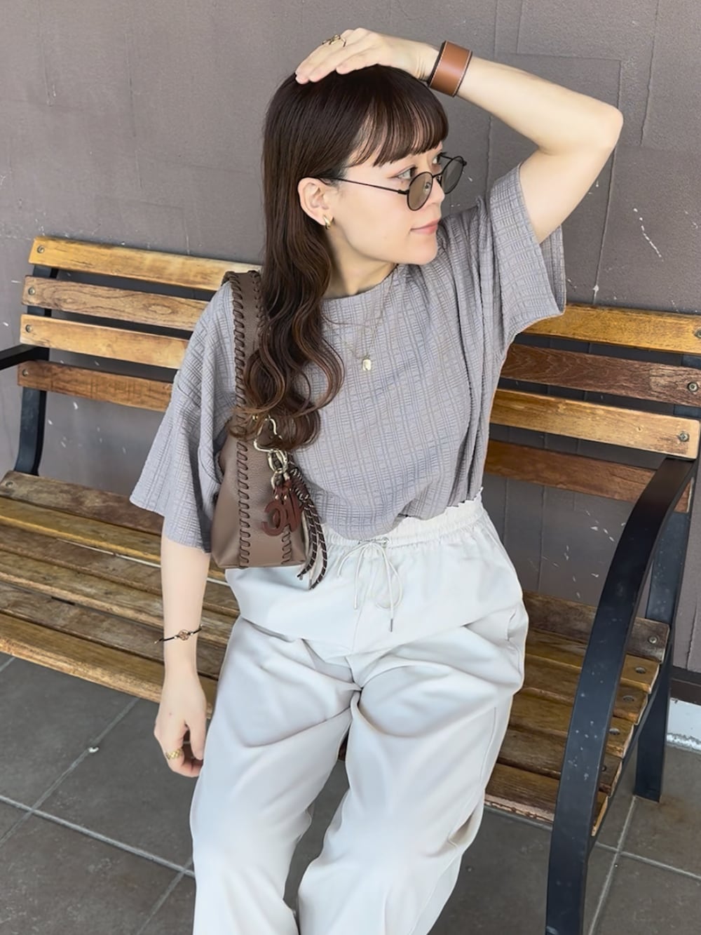 ベージュ系のTシャツ/カットソー、ホワイト系のその他パンツ、ブラウン系のバッグを着用したレディースの夏コーディネートの2枚目の写真