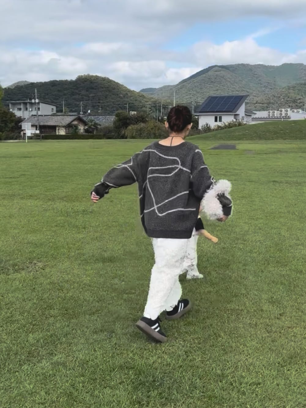 ブラウン系のカーディガン/ボレロ、ホワイト系のワンピース/ドレス、ブラック系のスニーカーを着用したレディースの秋コーディネートの3枚目の写真