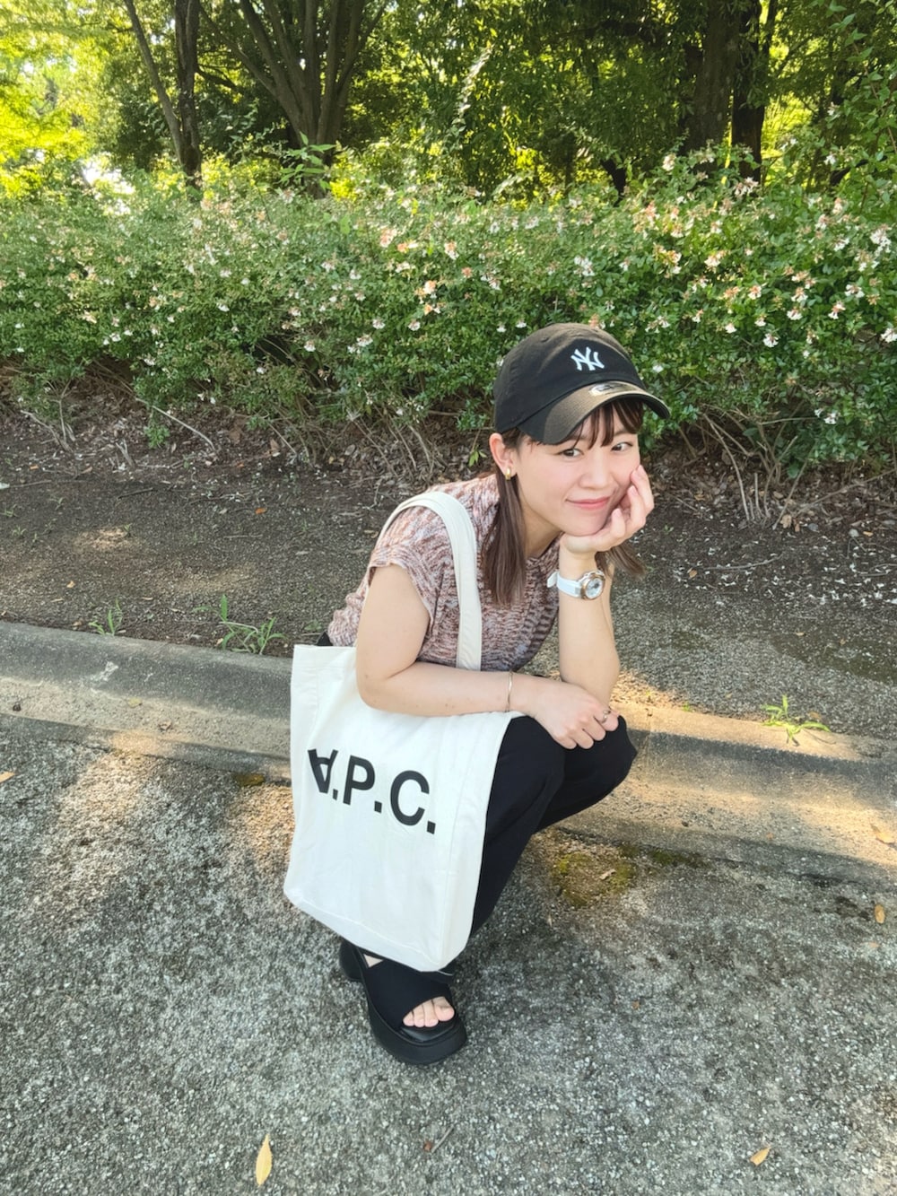 ピンク系のニット/セーター、ブラック系のデニムパンツ、ブラック系のサンダルを着用したレディースの夏コーディネートの2枚目の写真