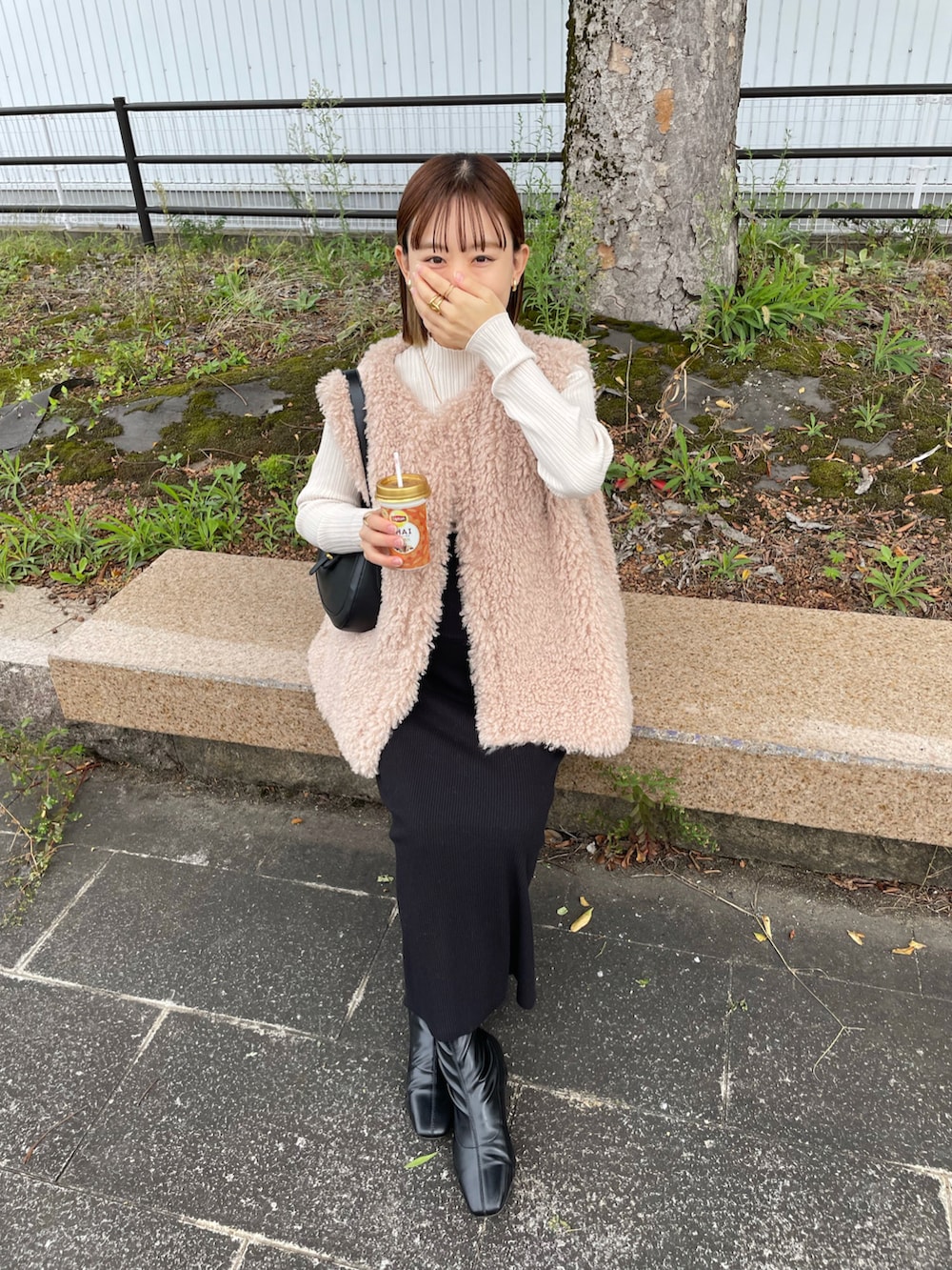 ホワイト系のベスト、ホワイト系のニット/セーター、ブラック系のバッグを着用したレディースの秋コーディネートの5枚目の写真