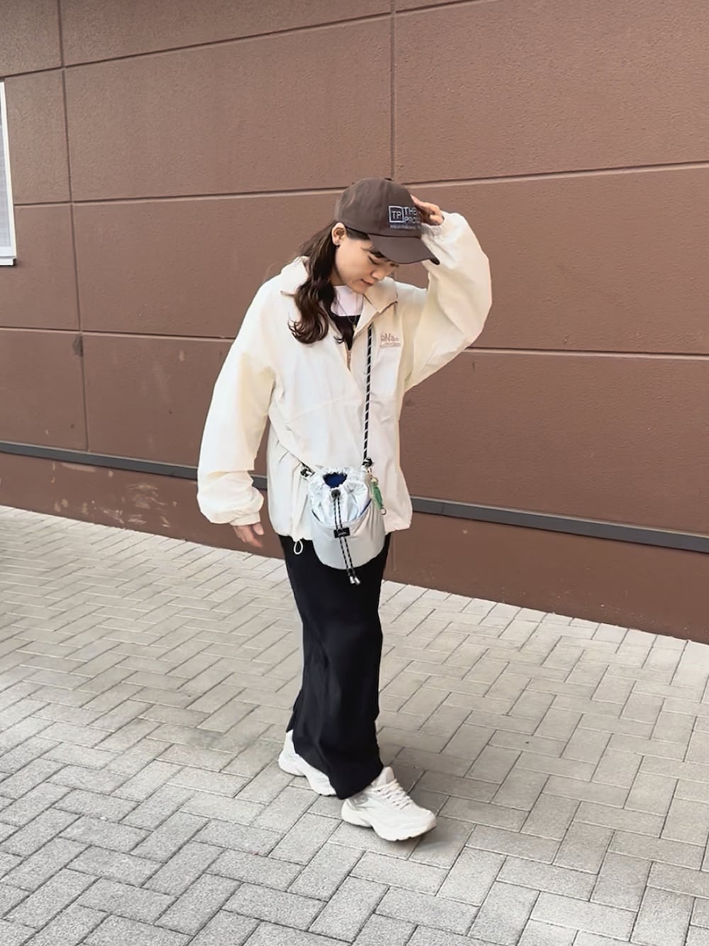 ホワイト系のブルゾン、ブラック系のワンピース、ベージュ系のスニーカーを着用したレディースの春コーディネートの4枚目の写真