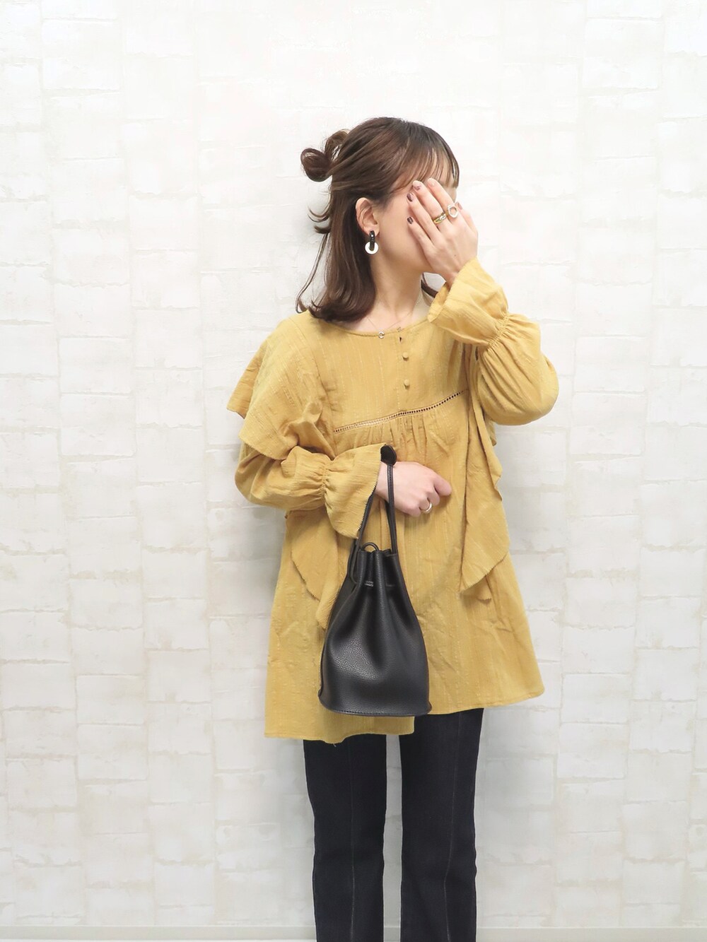 イエロー系のシャツ/ブラウス、ブルー系のデニムパンツ、ホワイト系のスニーカーを着用したレディースの冬コーディネートの3枚目の写真