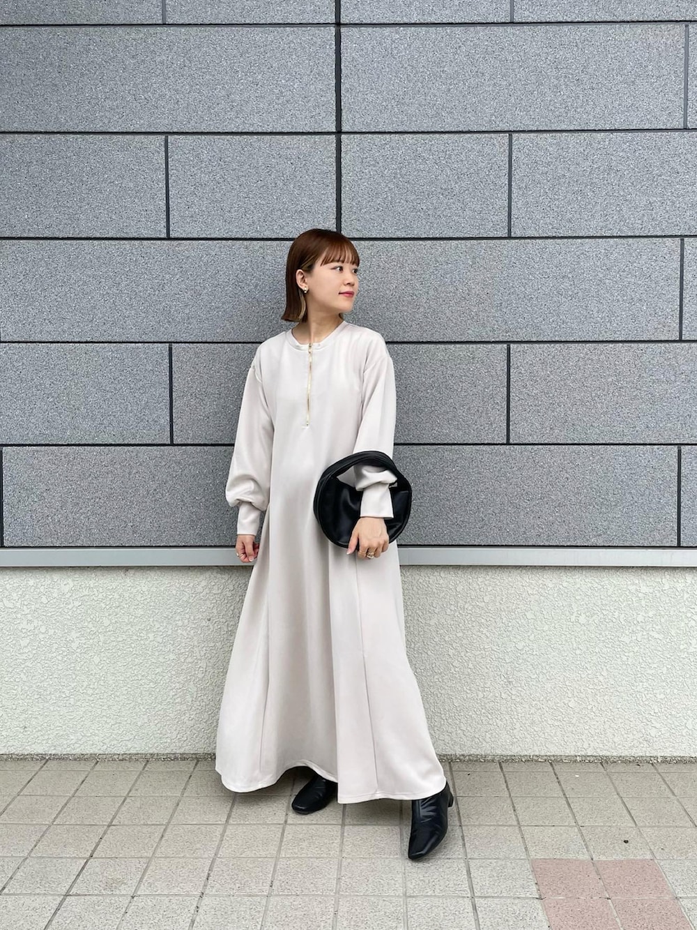ホワイト系のワンピース、ベージュ系のその他アウター、ブラック系のハンドバッグを着用したレディースの秋コーディネートの3枚目の写真