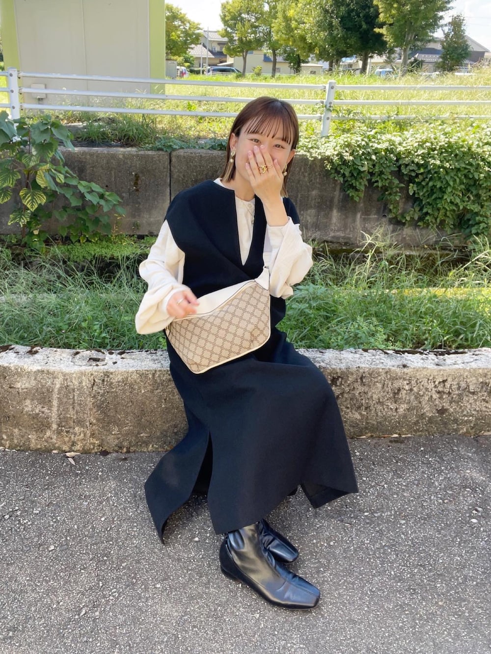 ブラック系のワンピース、ホワイト系のシャツ/ブラウス、ブラック系のブーツを着用したレディースの秋コーディネートの3枚目の写真