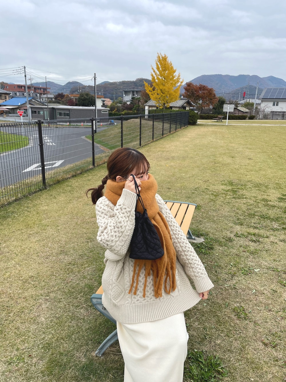 ホワイト系のニット/セーター、ホワイト系のスカート、ブラック系のブーツを着用したレディースの冬コーディネートの5枚目の写真