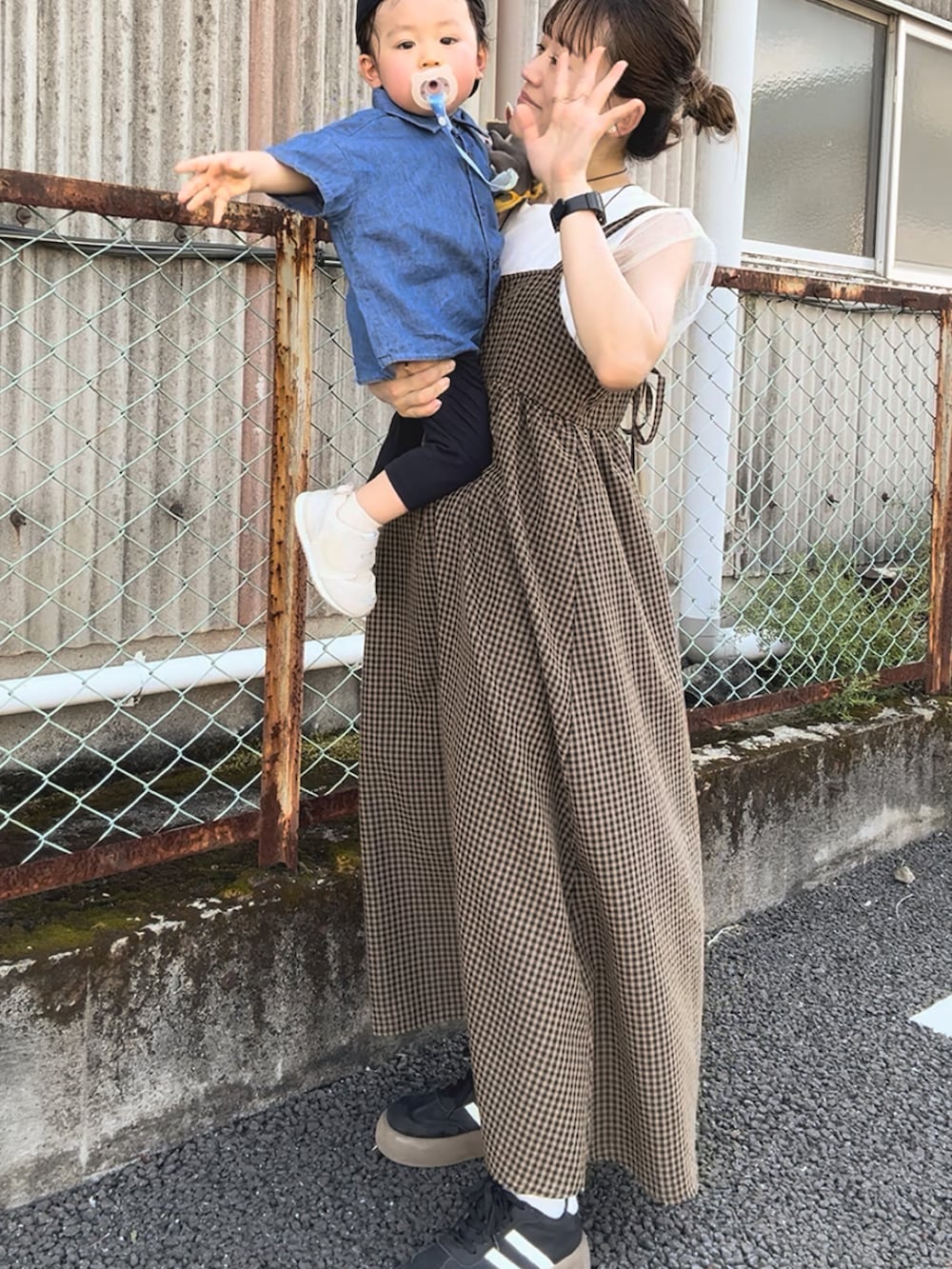 ブラウン系のワンピース、ホワイト系のトップス、ブラック系のバッグを着用したレディースの秋コーディネートの3枚目の写真