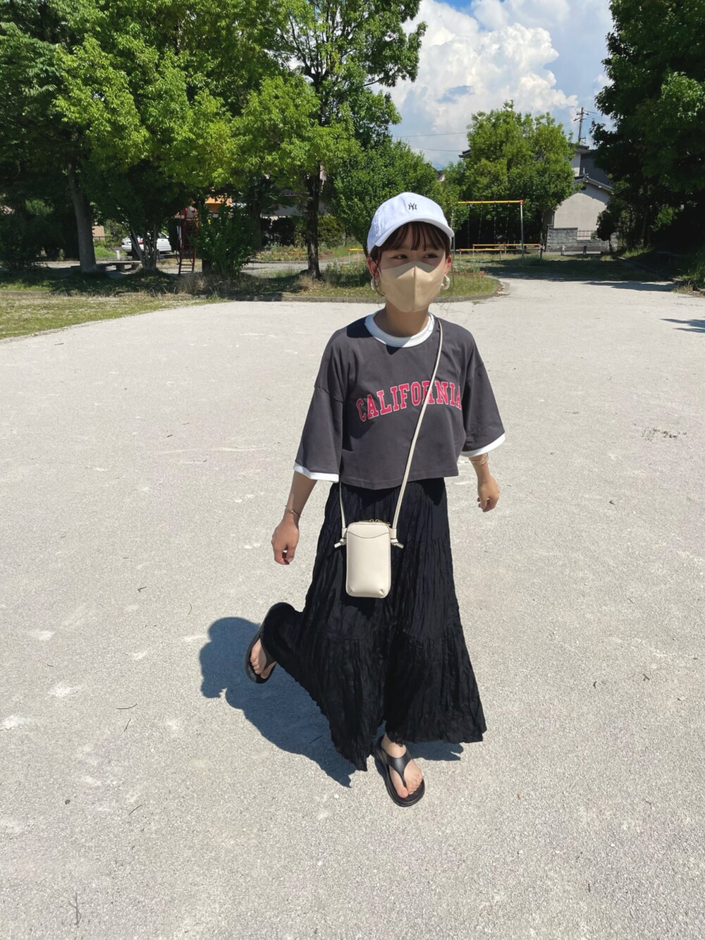 グレー系のTシャツ/カットソー、ブラック系のスカート、ホワイト系のキャップを着用したレディースの夏コーディネートの4枚目の写真