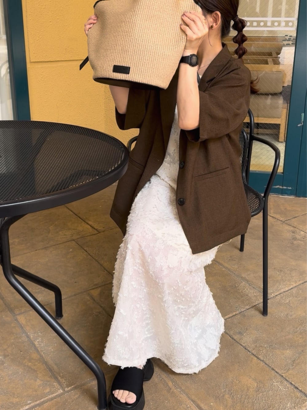 ブラウン系のテーラードジャケット、ブラック系のトートバッグ、ホワイト系のワンピース/ドレスを着用したレディースの夏コーディネートの4枚目の写真