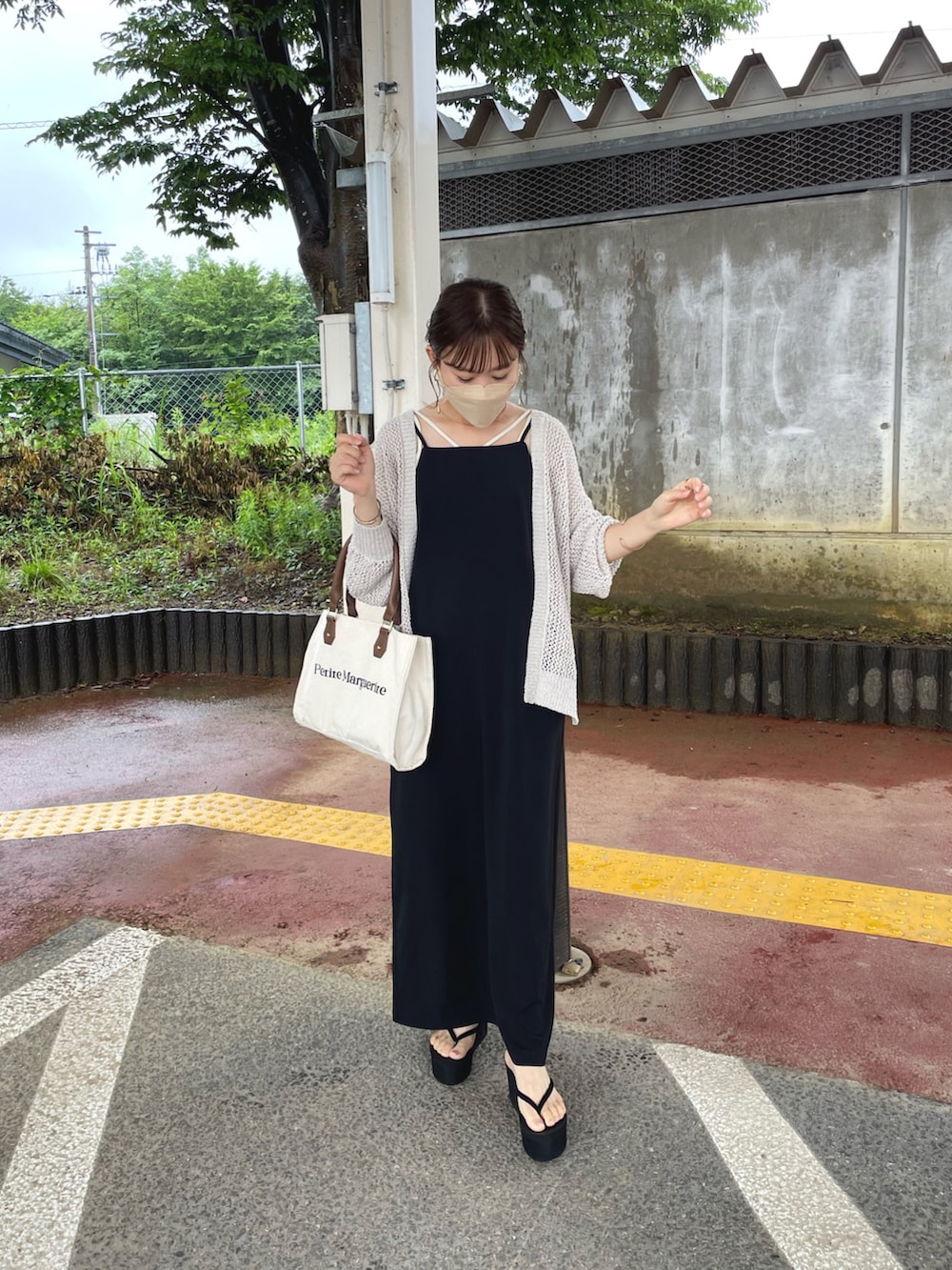 ホワイト系のカーディガン/ボレロ、ブラック系のワンピース、ホワイト系のキャミソールを着用したレディースの夏コーディネートの4枚目の写真