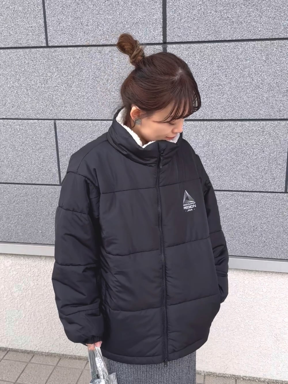 ブラック系のブルゾン、グレー系のTシャツ/カットソー、グレー系のスカートを着用したレディースの冬コーディネートの4枚目の写真