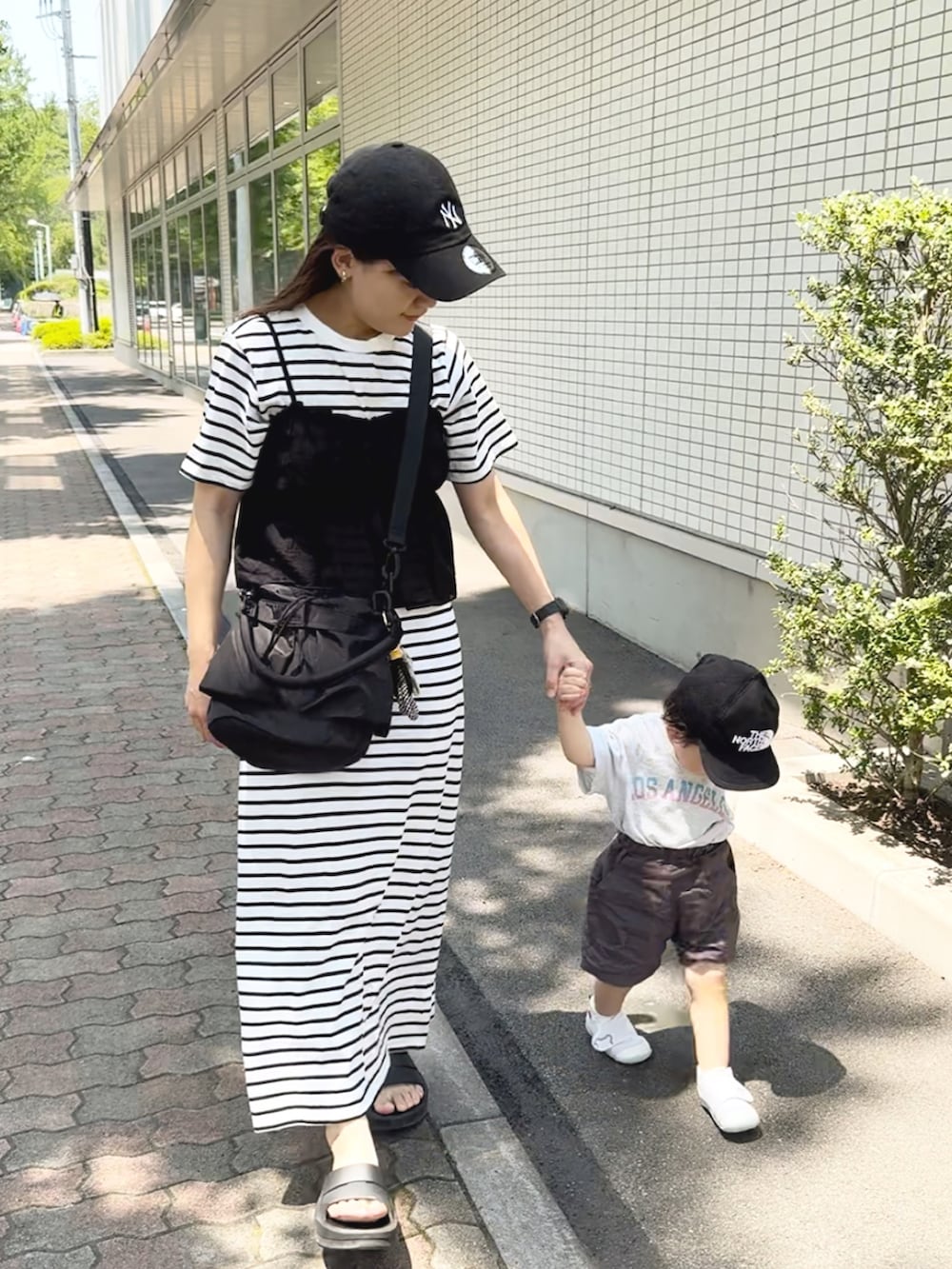 ブラック系のサンダル、ホワイト系のトップス、ホワイト系のワンピース/ドレスを着用したレディースの夏コーディネートの2枚目の写真