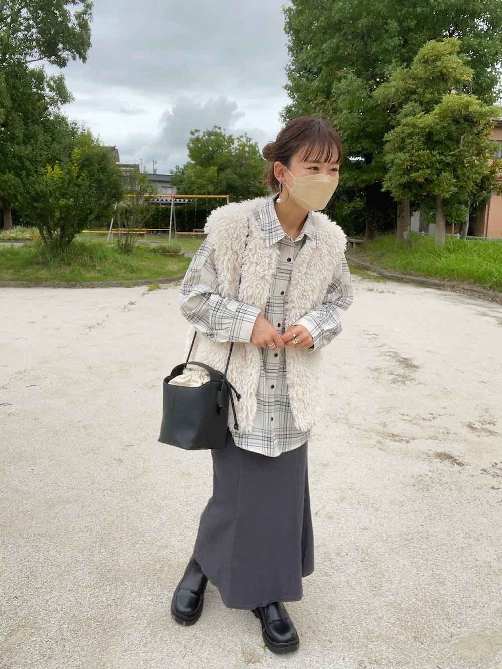 ホワイト系のベスト、ホワイト系のシャツ/ブラウス、グレー系のスカートを着用したレディースの秋コーディネートの4枚目の写真