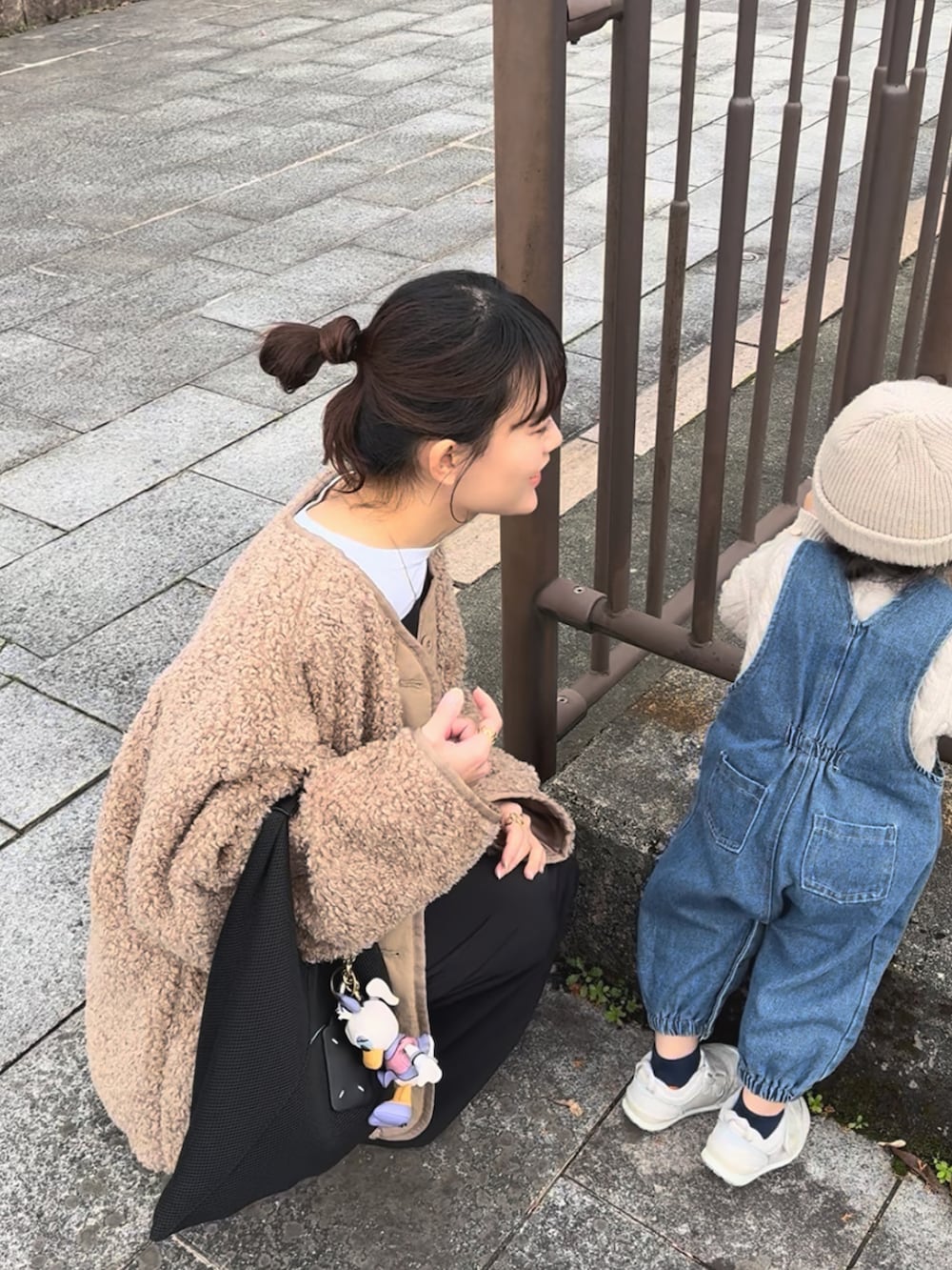 ブラック系のワンピース、ベージュ系のブルゾン、ブラック系のブーツを着用したレディースの冬コーディネートの4枚目の写真