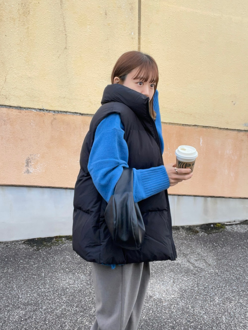 ブルー系のニット/セーター、ブラック系のベスト、ブラウン系のパンツを着用したレディースの秋コーディネートの3枚目の写真