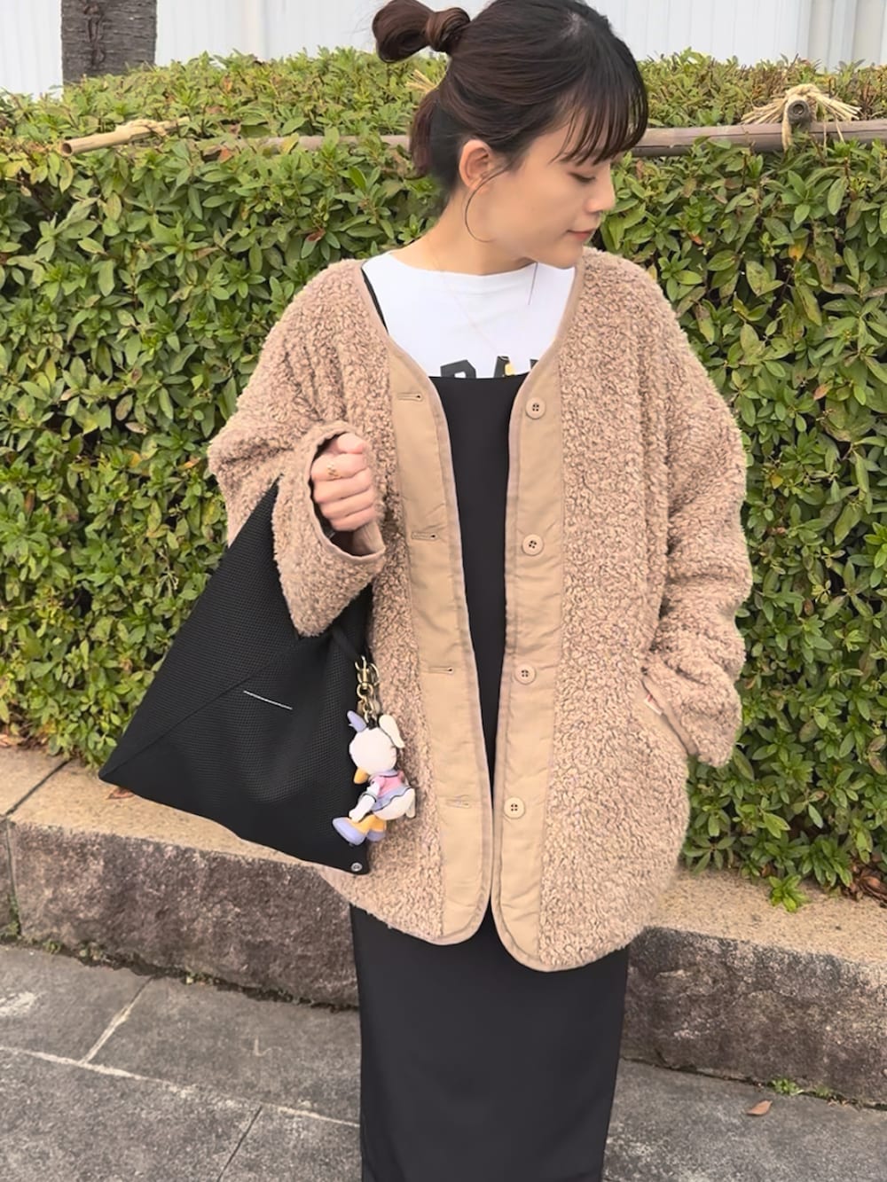 ブラック系のワンピース、ベージュ系のブルゾン、ブラック系のブーツを着用したレディースの冬コーディネートの3枚目の写真