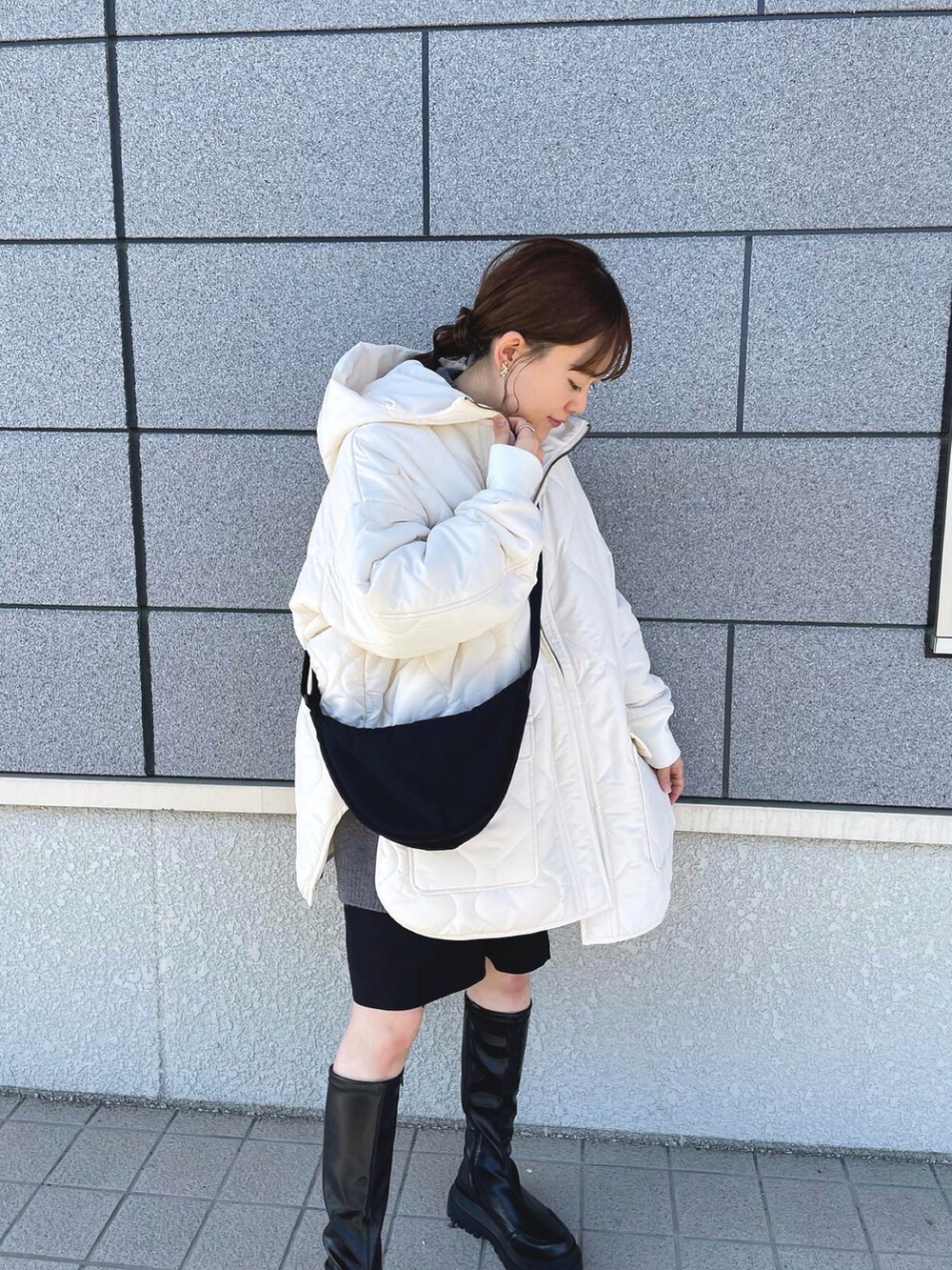 ホワイト系のブルゾン、グレー系のニット/セーター、ブラック系のショルダーバッグを着用したレディースの冬コーディネートの3枚目の写真