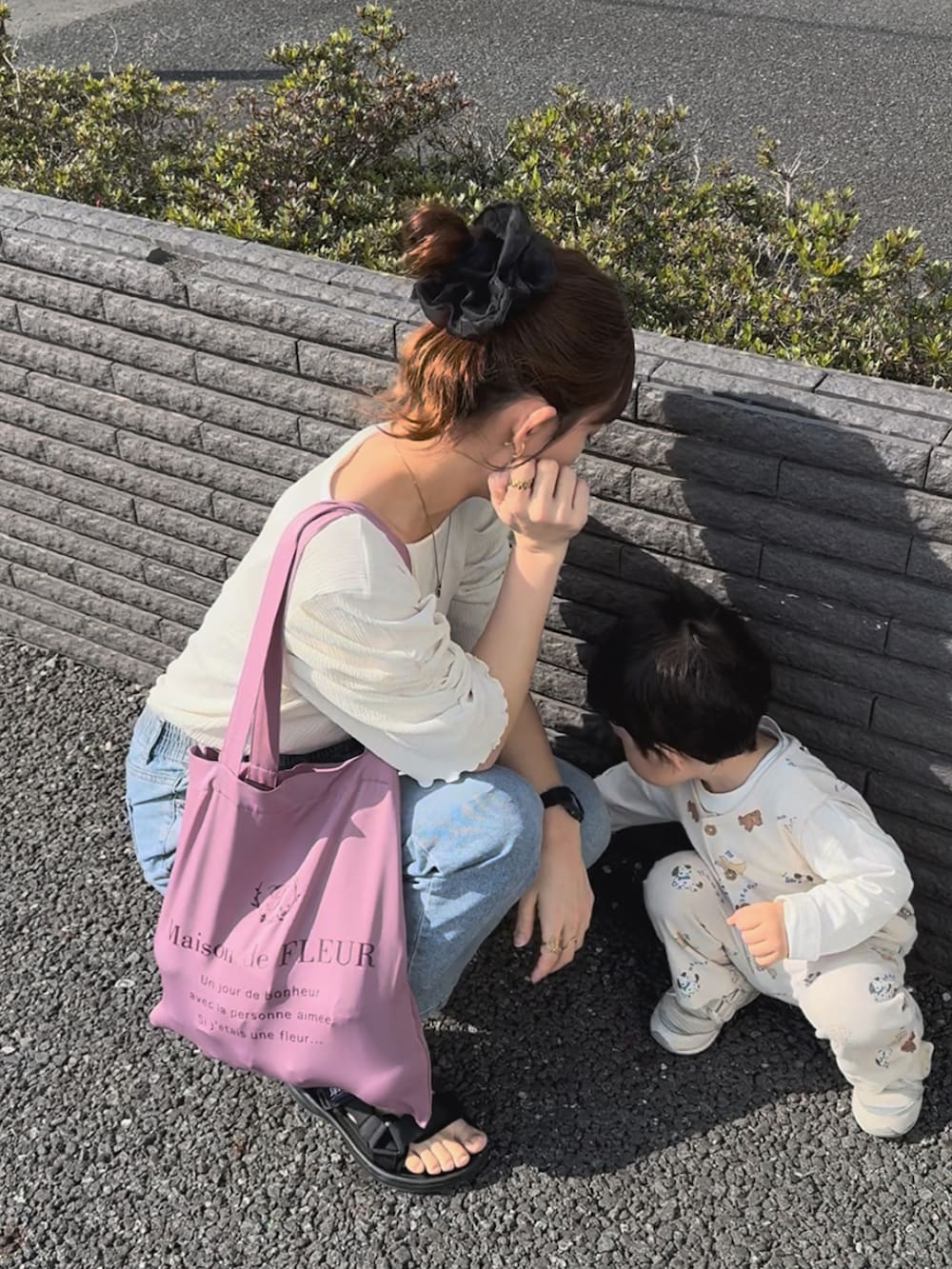 ブラック系のサンダル、ホワイト系のトップス、ブルー系のデニムパンツを着用したレディースの夏コーディネートの4枚目の写真