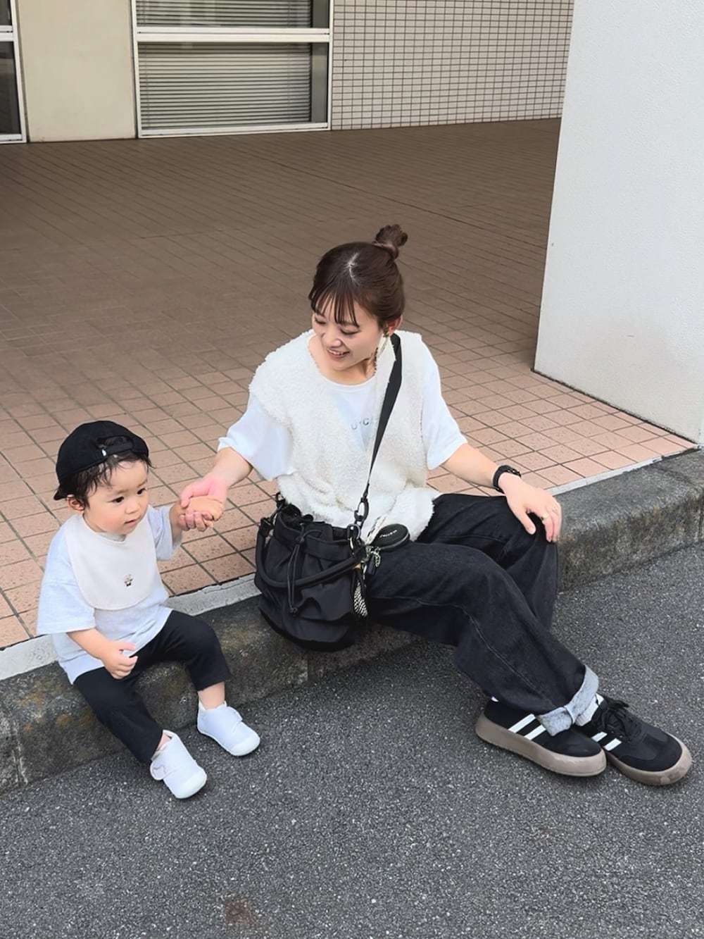 ホワイト系のトップス、ブラック系のパンツ、ブラック系のバッグを着用したレディースの秋コーディネートの5枚目の写真